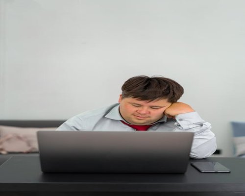 Person resting their eyes away from laptop screen